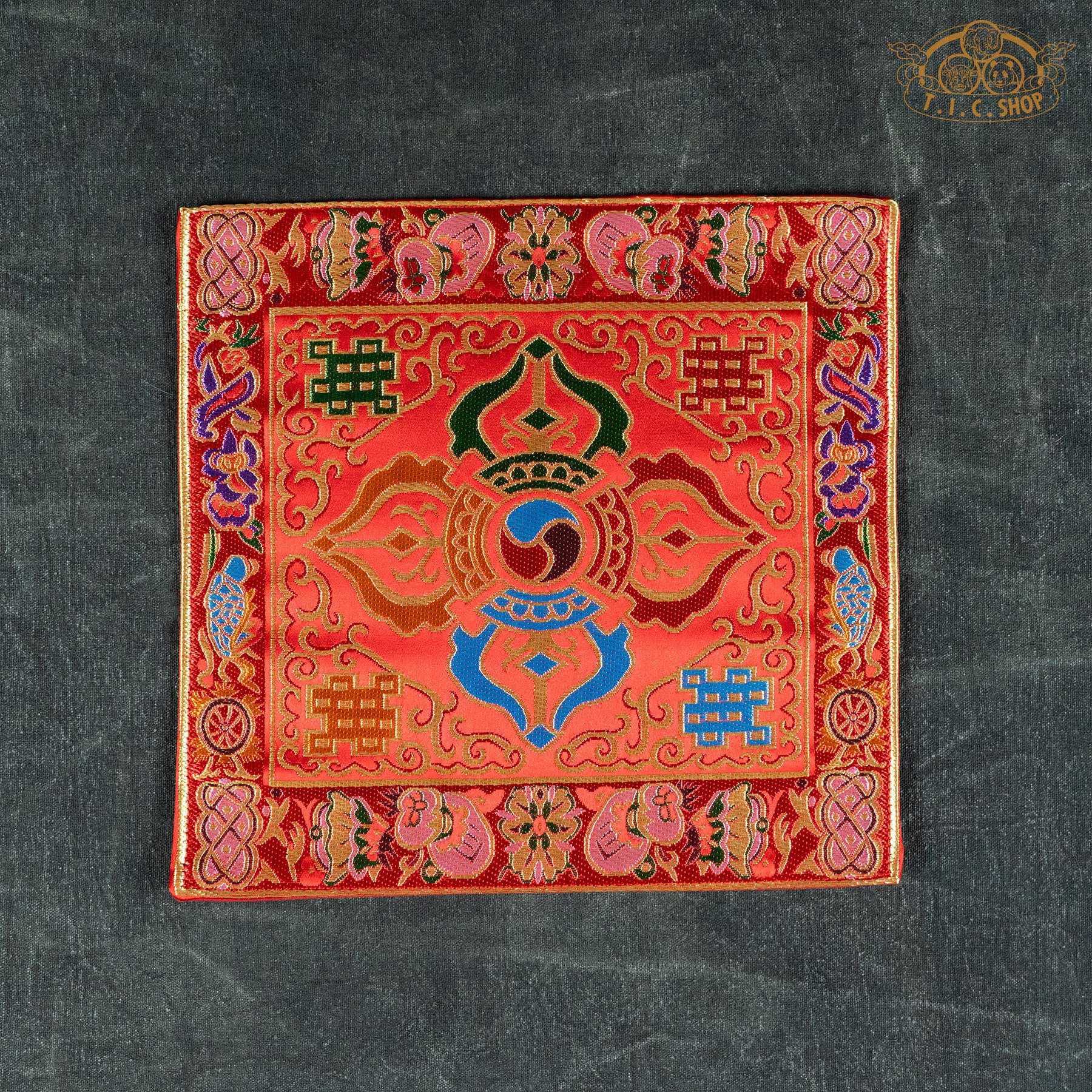 Square red Tibetan brocade mat featuring a central Double Vajra design and intricate colorful silk-style embroidery.