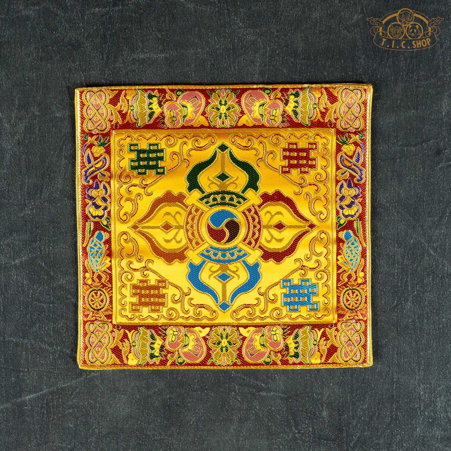 Square yellow Tibetan brocade mat featuring a central Double Vajra design and intricate colorful silk-style embroidery.