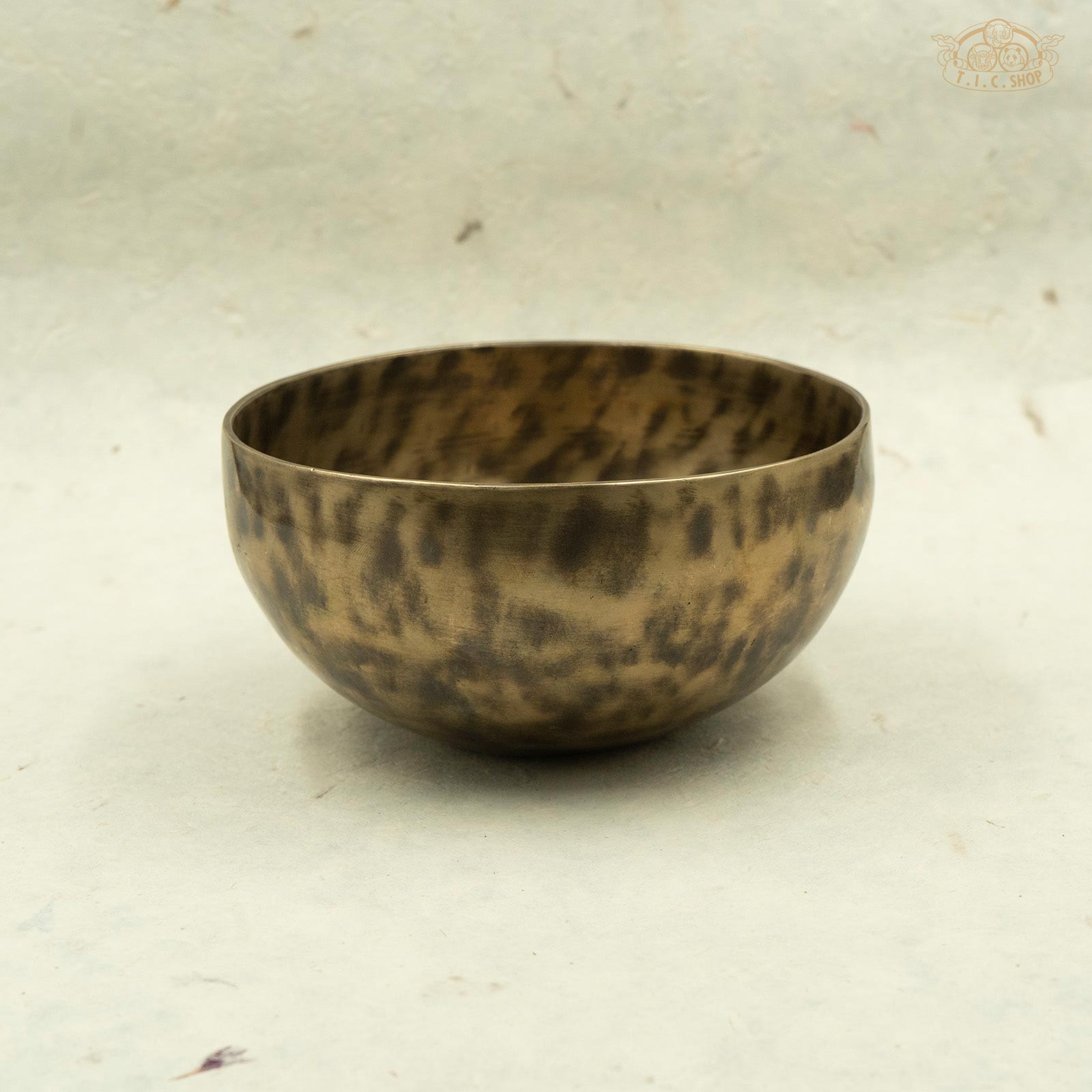 Side view of Tibetan antique brass singing bowl with a mottled pattern, handcrafted in Nepal.For meditation