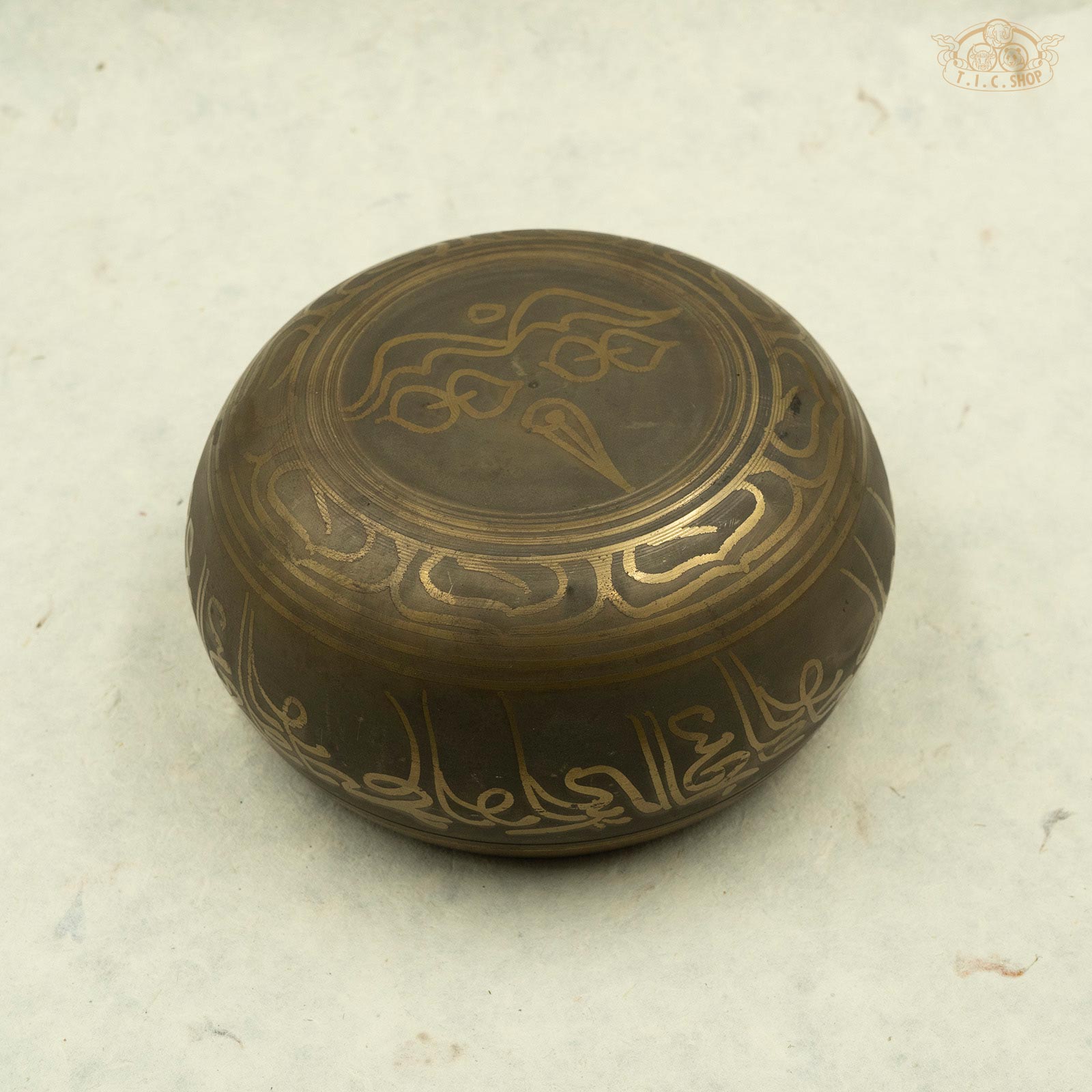 Back view of Tibetan brass singing bowl with an image of five buddhas seated around the rim, with Buddha Eyes symbol, handcrafted in Nepal for meditation