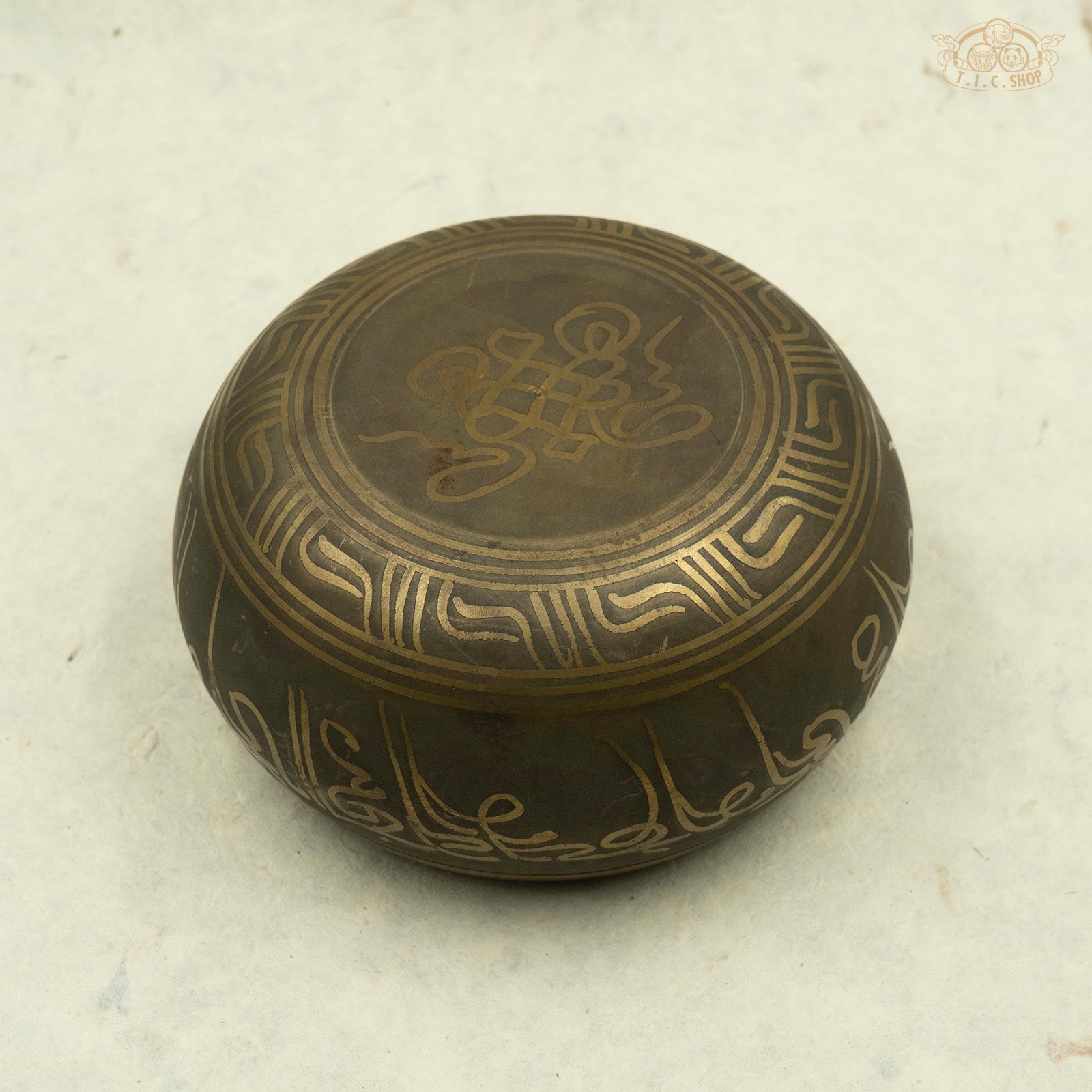 Back view of Tibetan brass singing bowl with intricate symbols and designs, handcrafted in Nepal.