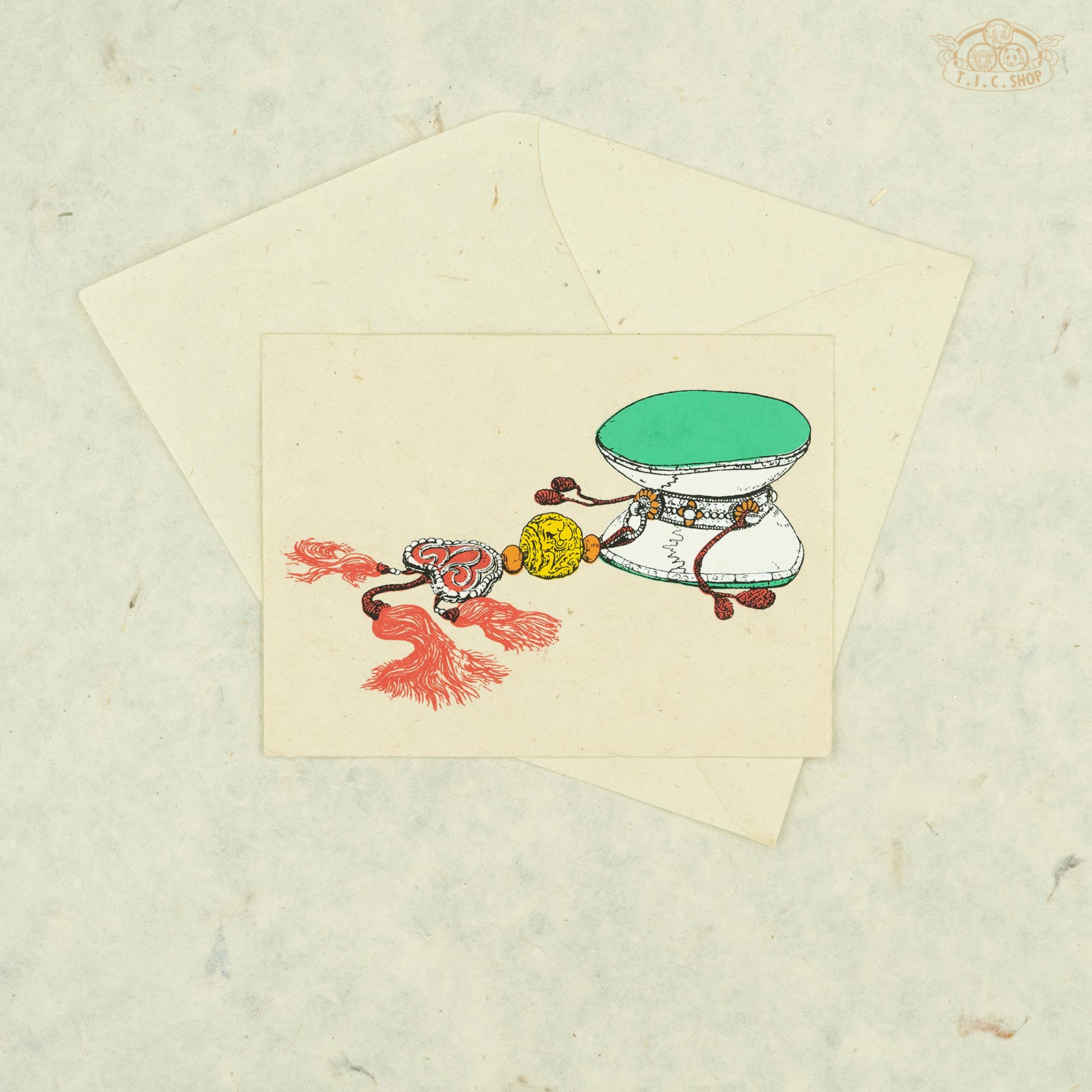 Handmade Nepalese Lokta paper greeting card featuring the Tibetan Damaru drum symbol for spiritual awakening and Dharma