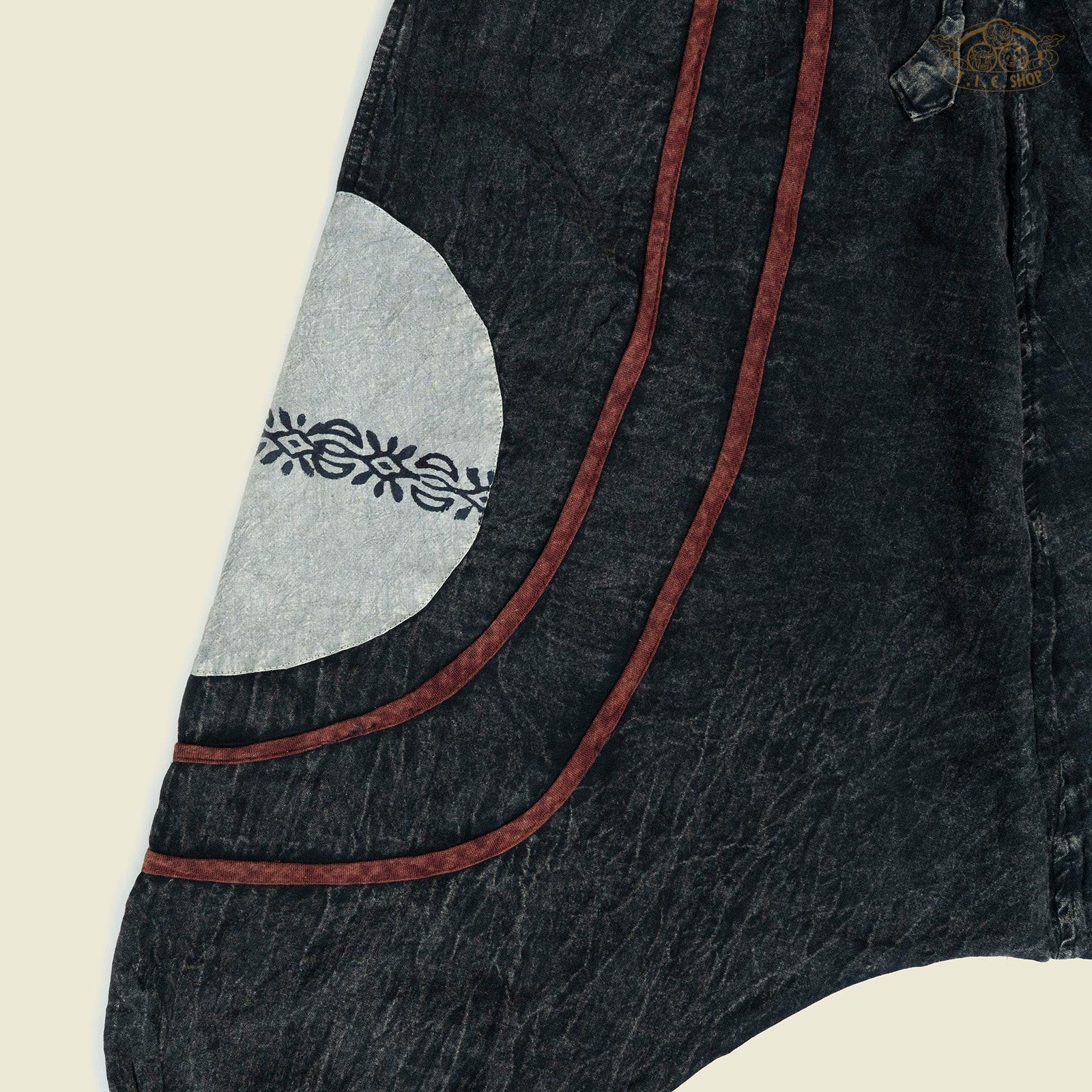 Detail of the elastic cuff and drawstring waist of the patterned harem trousers.