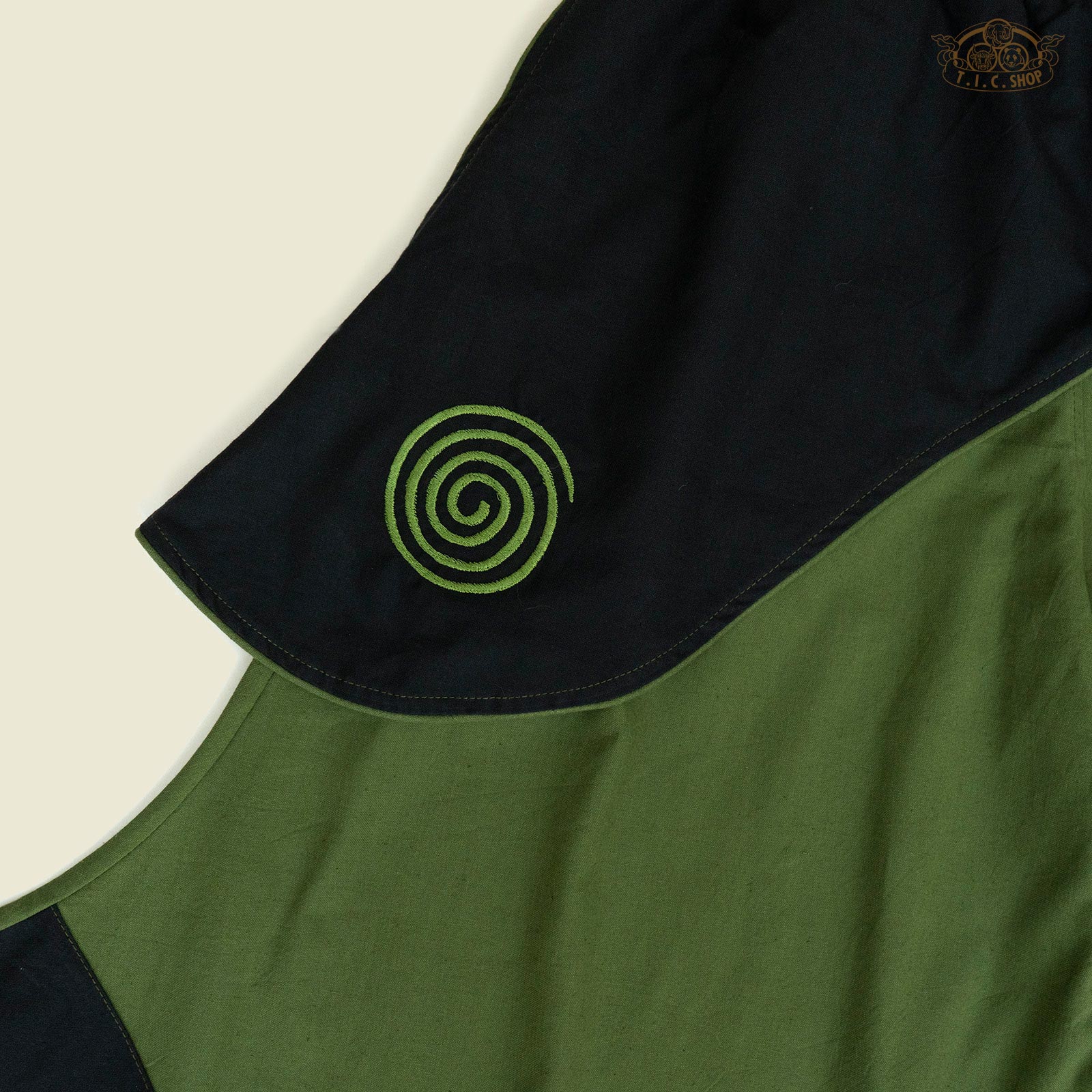 Close-up of spiral embroidery detail on cotton fabric.