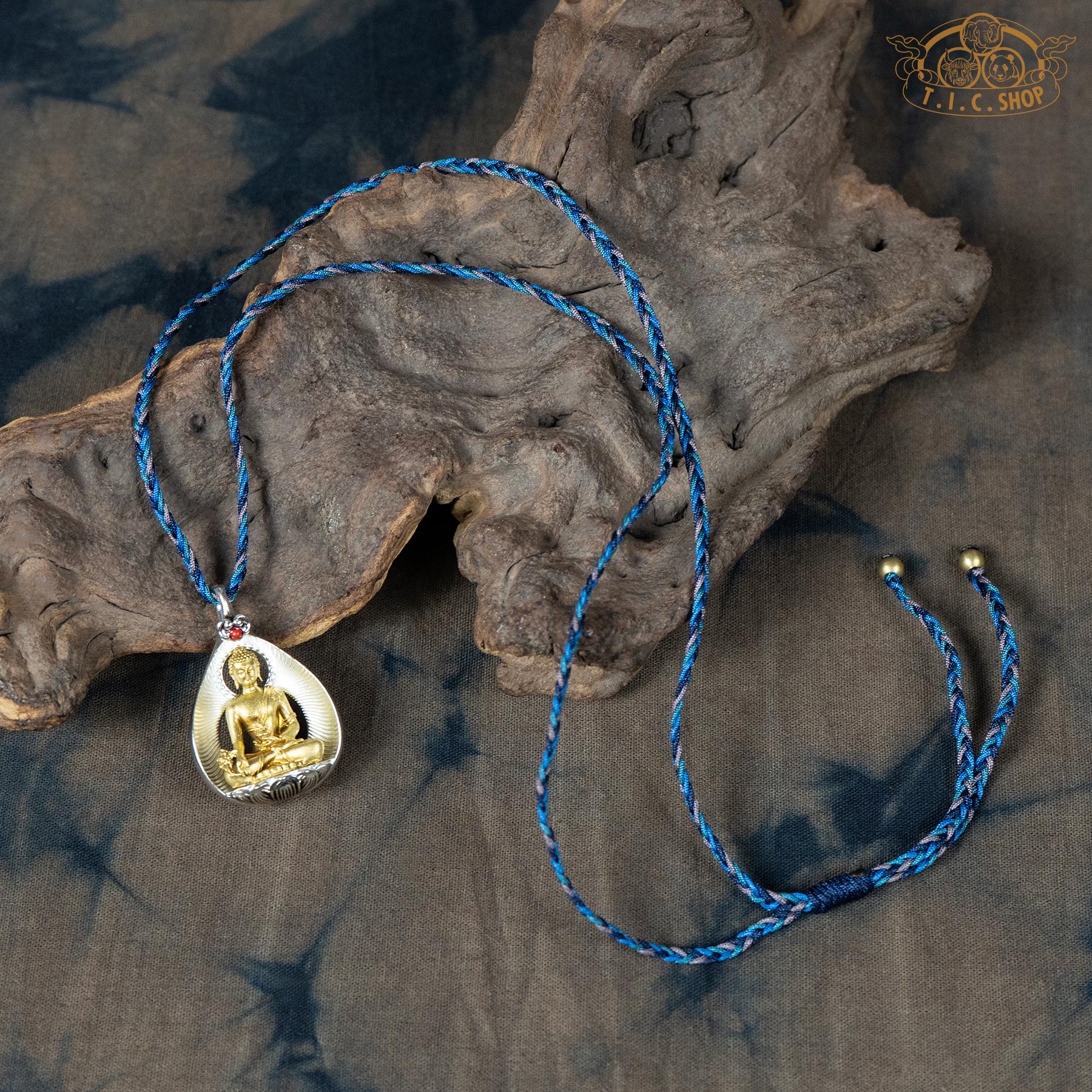 Sculpted Medicine Buddha amulet pendant displayed with hand-woven blue rope necklace
