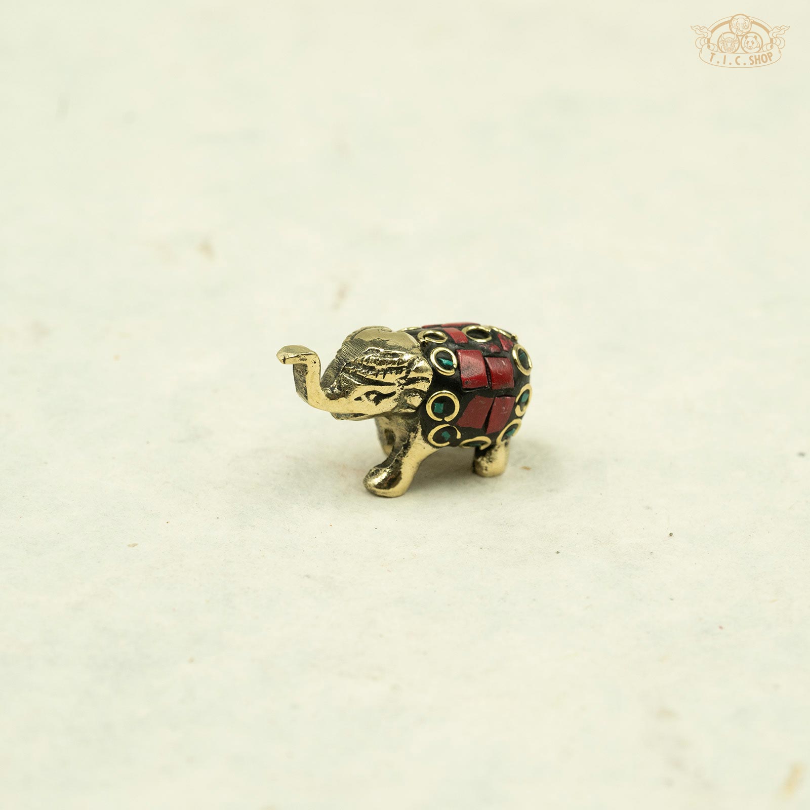 rad color_Side view of small brass elephant incense stand showing detailed artisan carving.