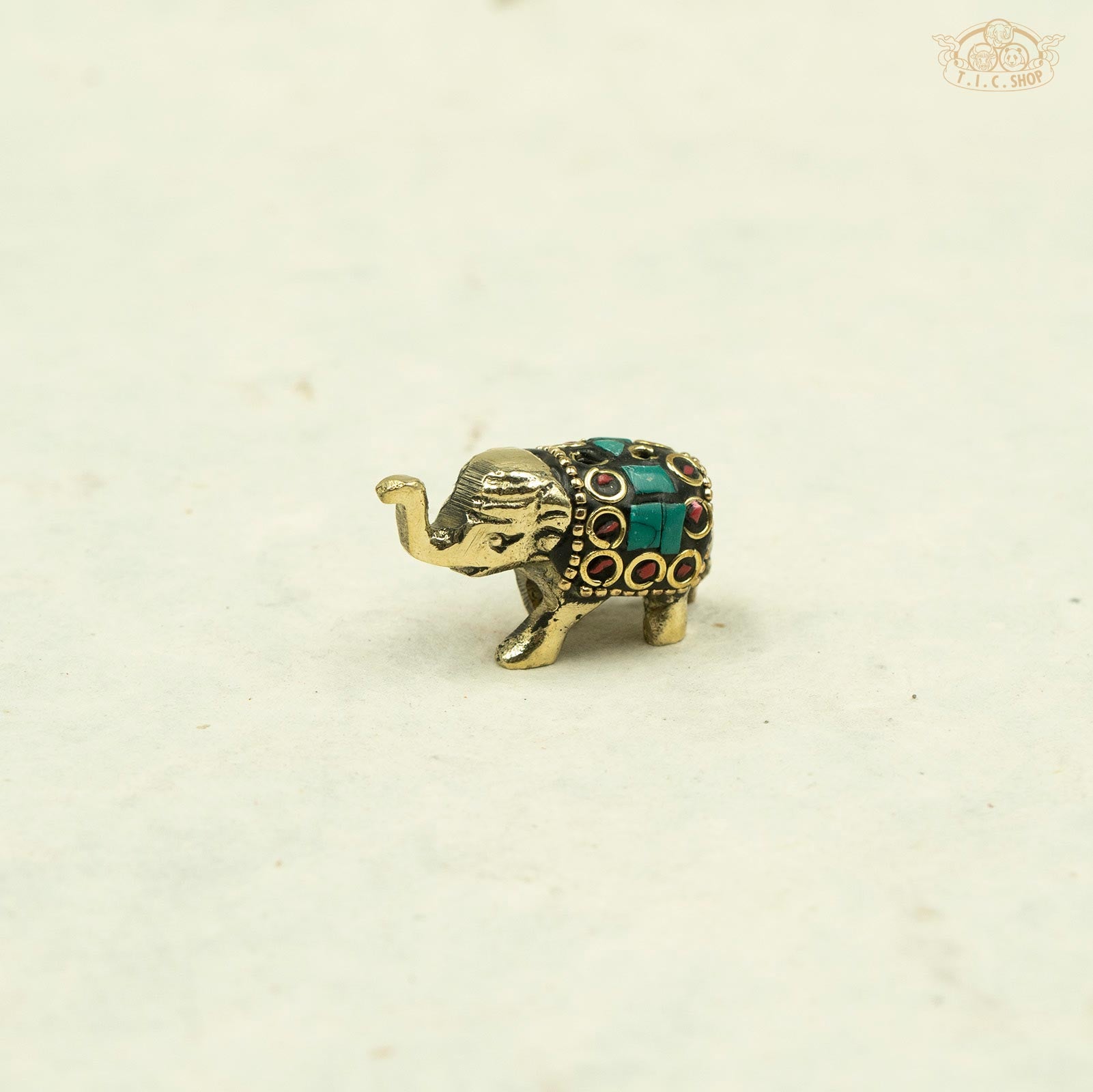 green color_Side view of small brass elephant incense stand showing detailed artisan carving.