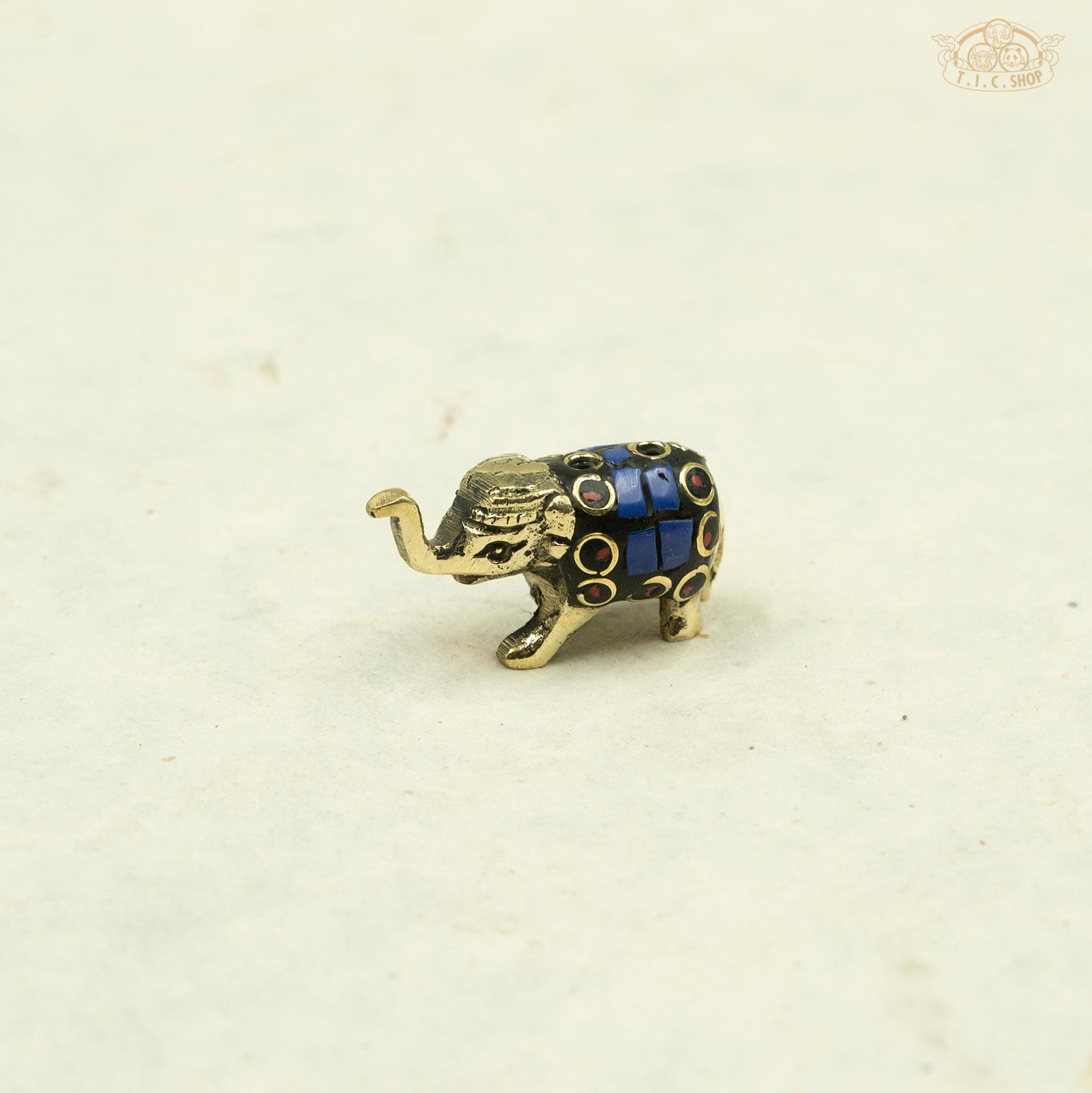 dark blue_Side view of small brass elephant incense stand showing detailed artisan carving.