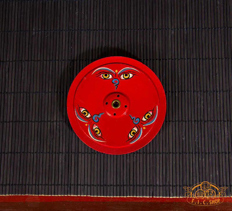Top view showing detailed Buddha eyes design on wooden incense holder.