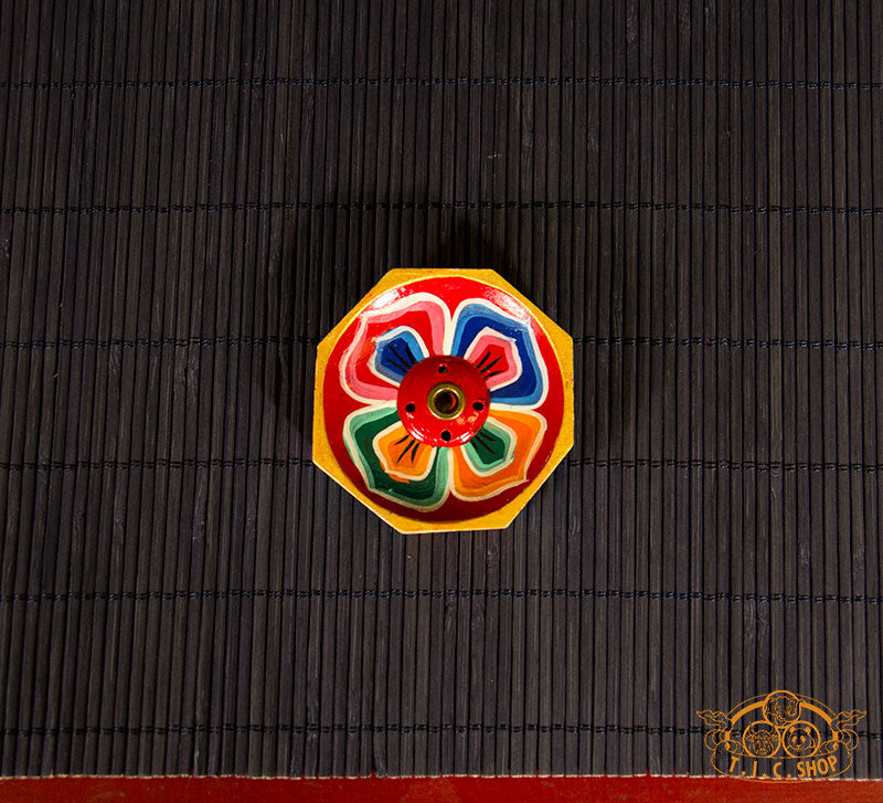 Top-down view of hand-painted octagonal wooden incense holder for Tibetan and Indian incense sticks.