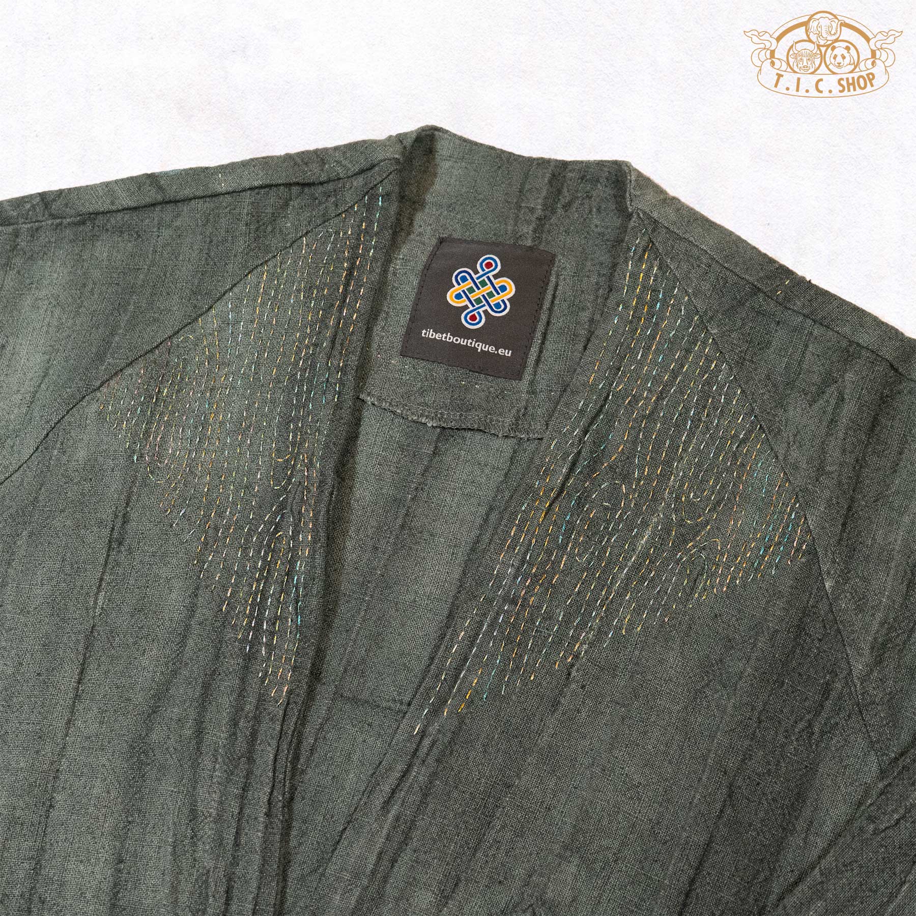 Close-up of the neckline featuring minimalist Sashiko hand-embroidery with elegant gold-thread accents.