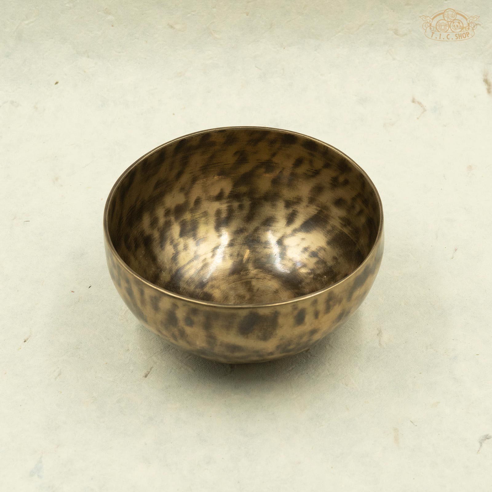 An antique brass singing bowl with a mottled pattern, handcrafted in Nepal.For meditation