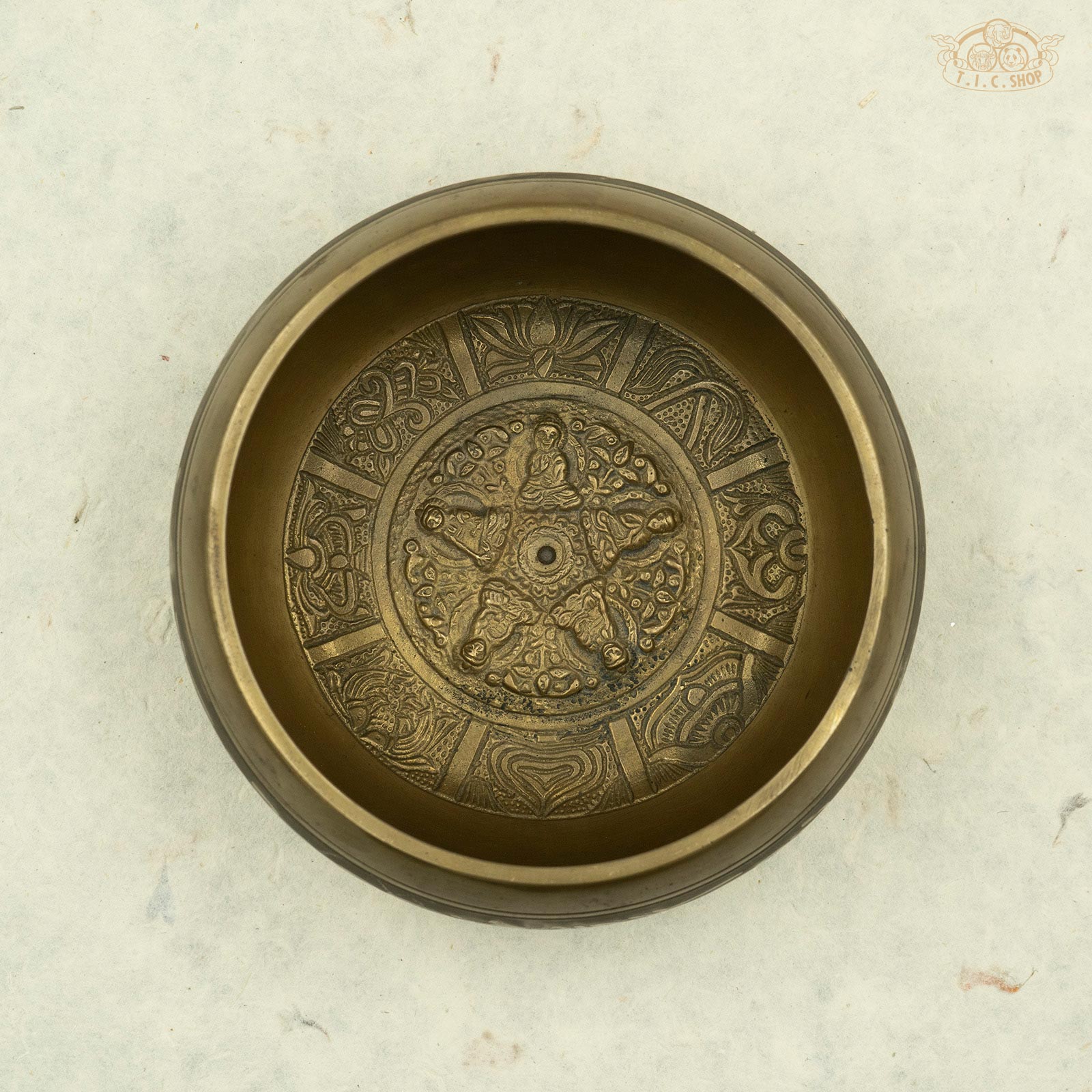 Top view of Tibetan brass singing bowl with intricate symbols and designs, handcrafted in Nepal.