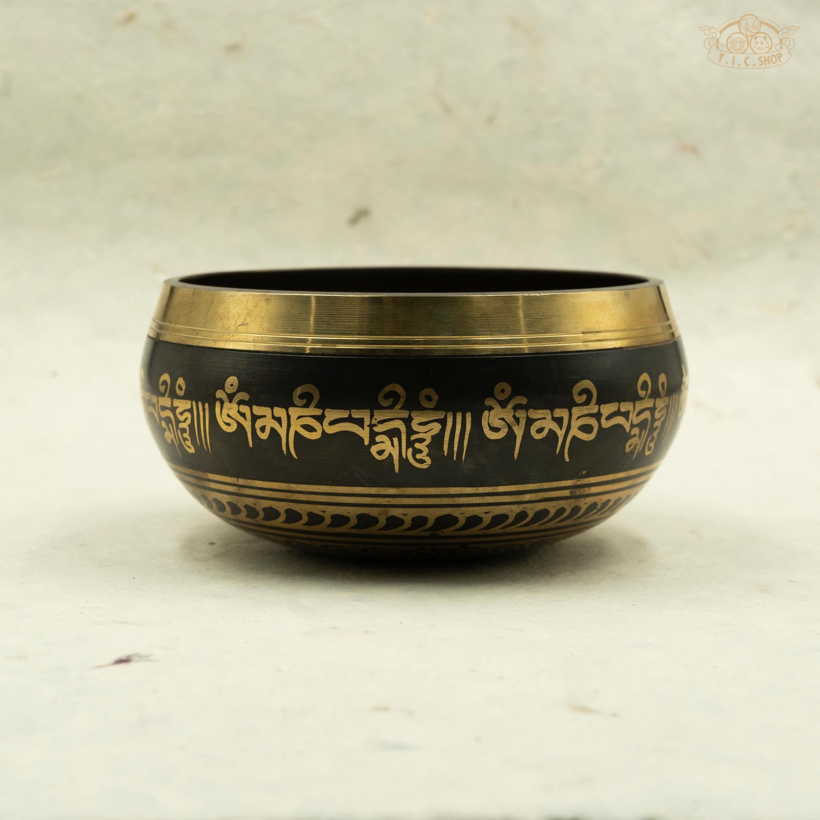 Side view of Vajra Singing Bowl displaying continuous Om Mani Padme Hum mantra band with traditional Tibetan decorative motifs.
