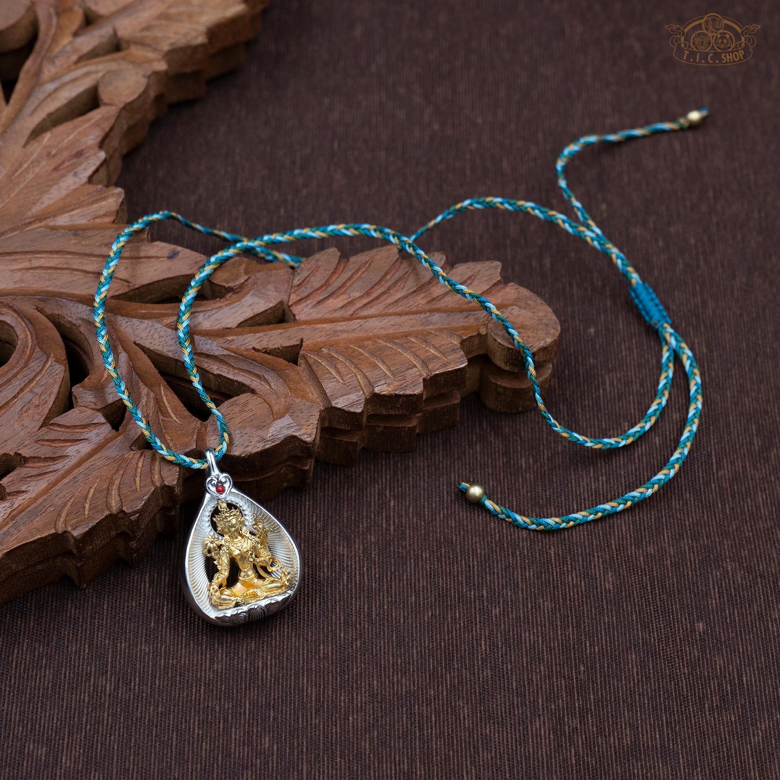 Sculpted Green Tara amulet pendant displayed with hand-woven green rope necklace