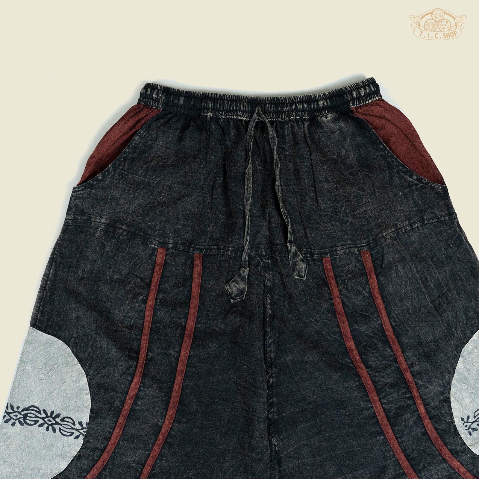 Close-up of the patchwork patterns and cotton fabric texture of the trousers.