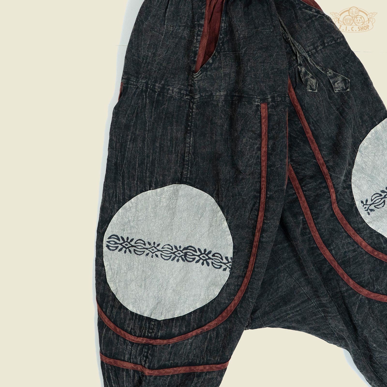 Side view showing the harem trousers’ side pocket and relaxed fit design.

