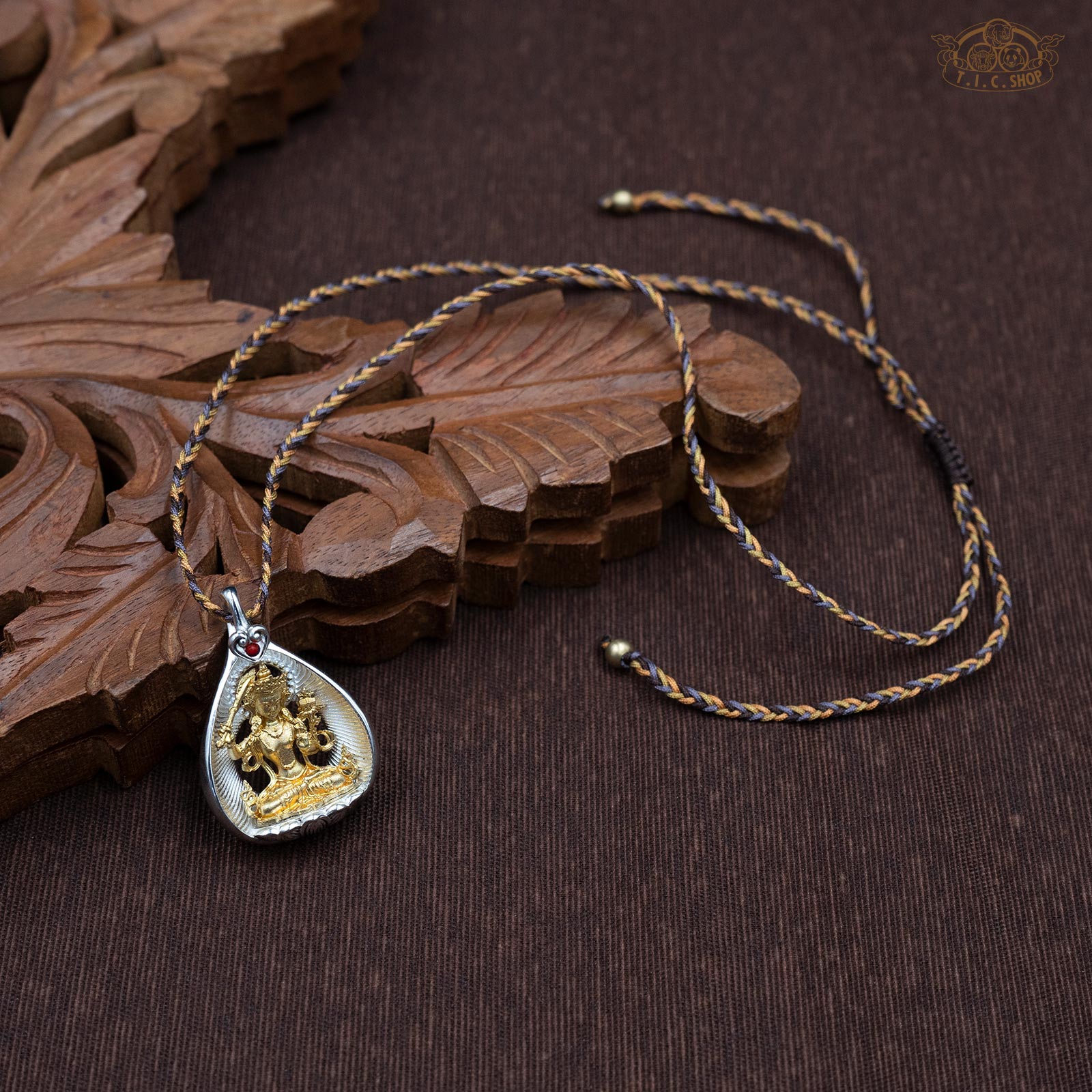 Sculpted Manjushri amulet pendant displayed with hand-woven yellow and brown rope necklace