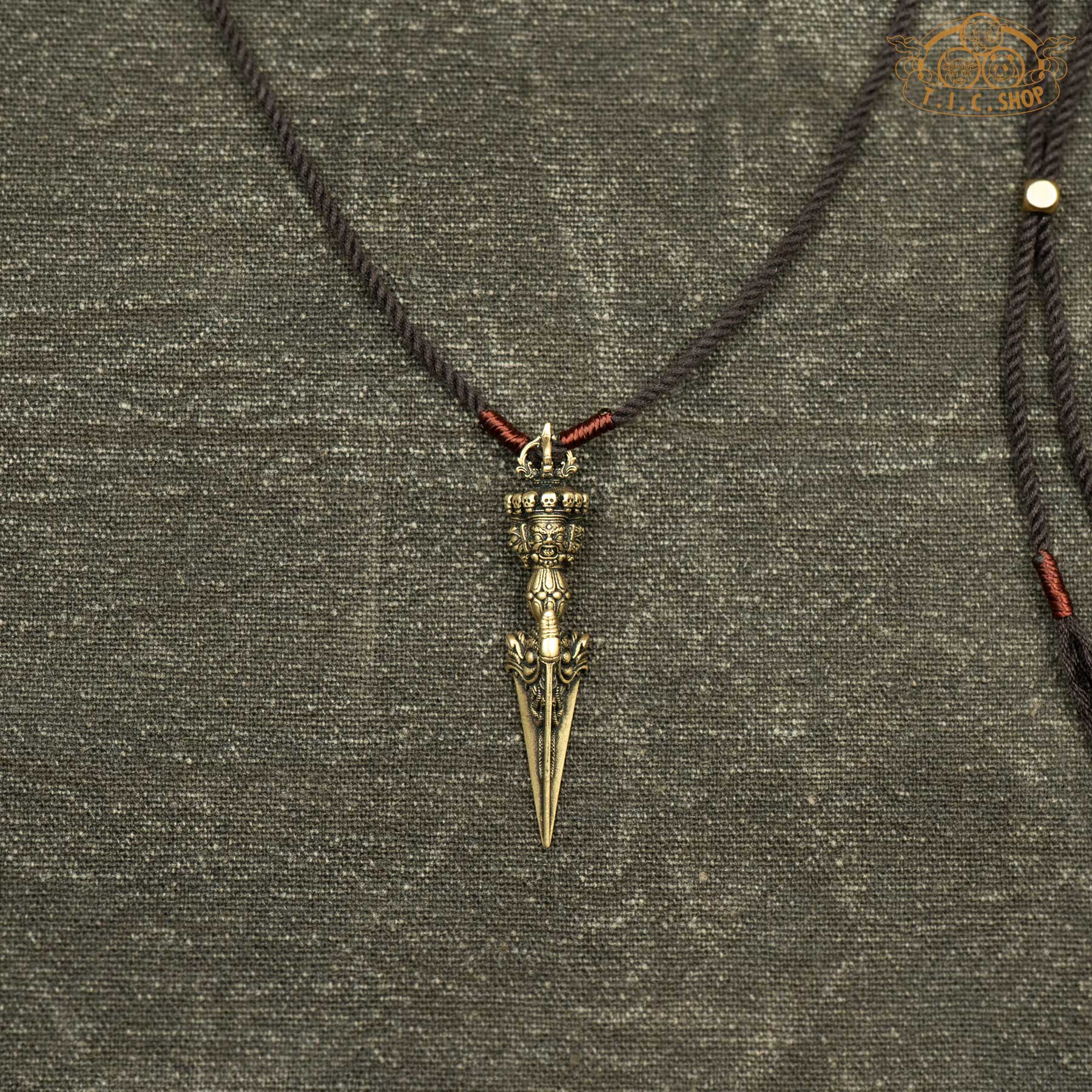 Sculpted antique brass phurba pendant showing finely carved details