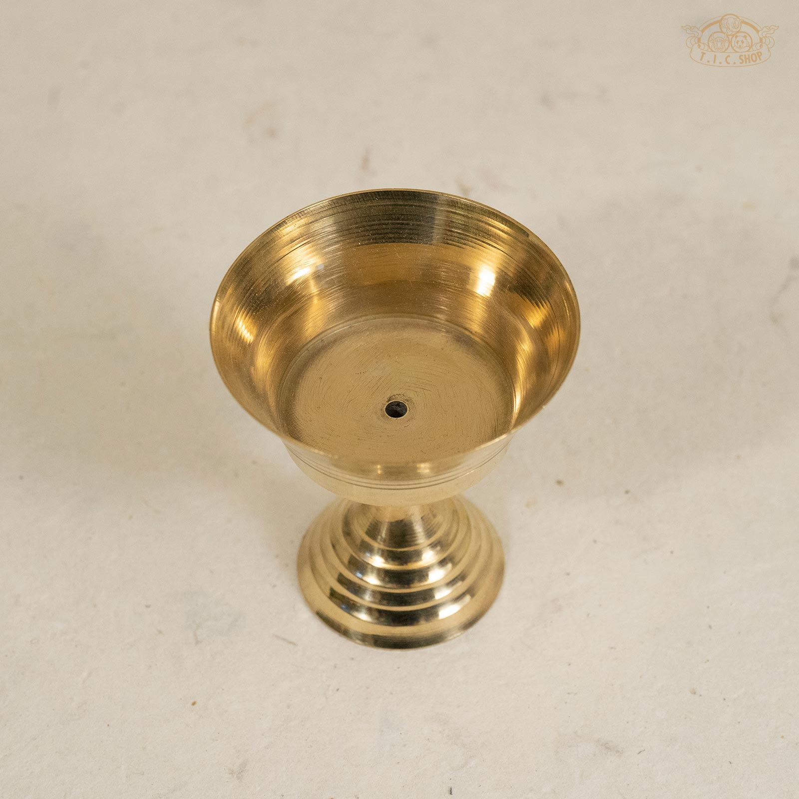 Top view of small Tibetan brass butter lamp showing round bowl and polished surface.