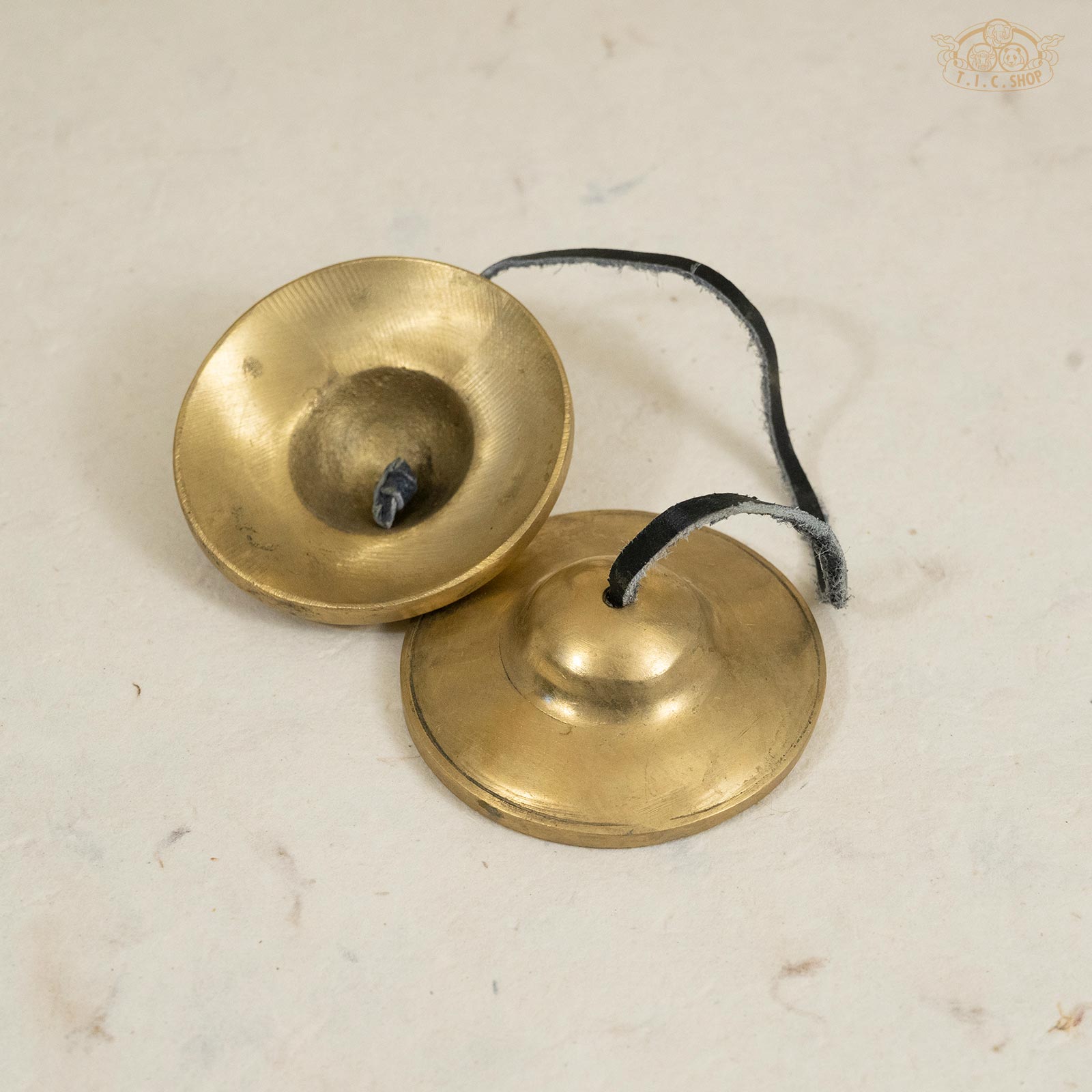 Back view of medium Tibetan brass Tingsha bells, showing smooth surface and polished finish.