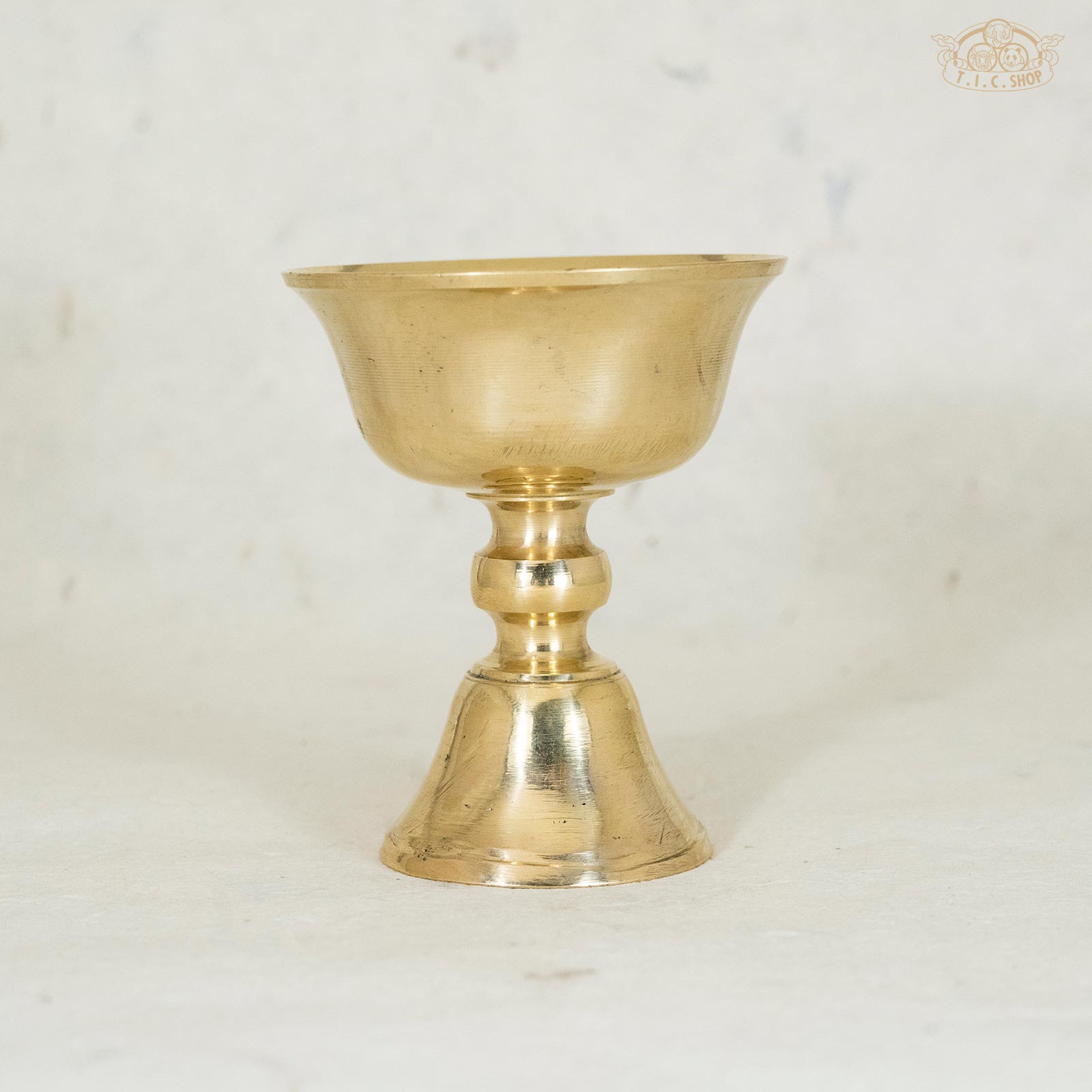 Front view of  Tibetan brass butter lamp showing pure golden color and classic shape.