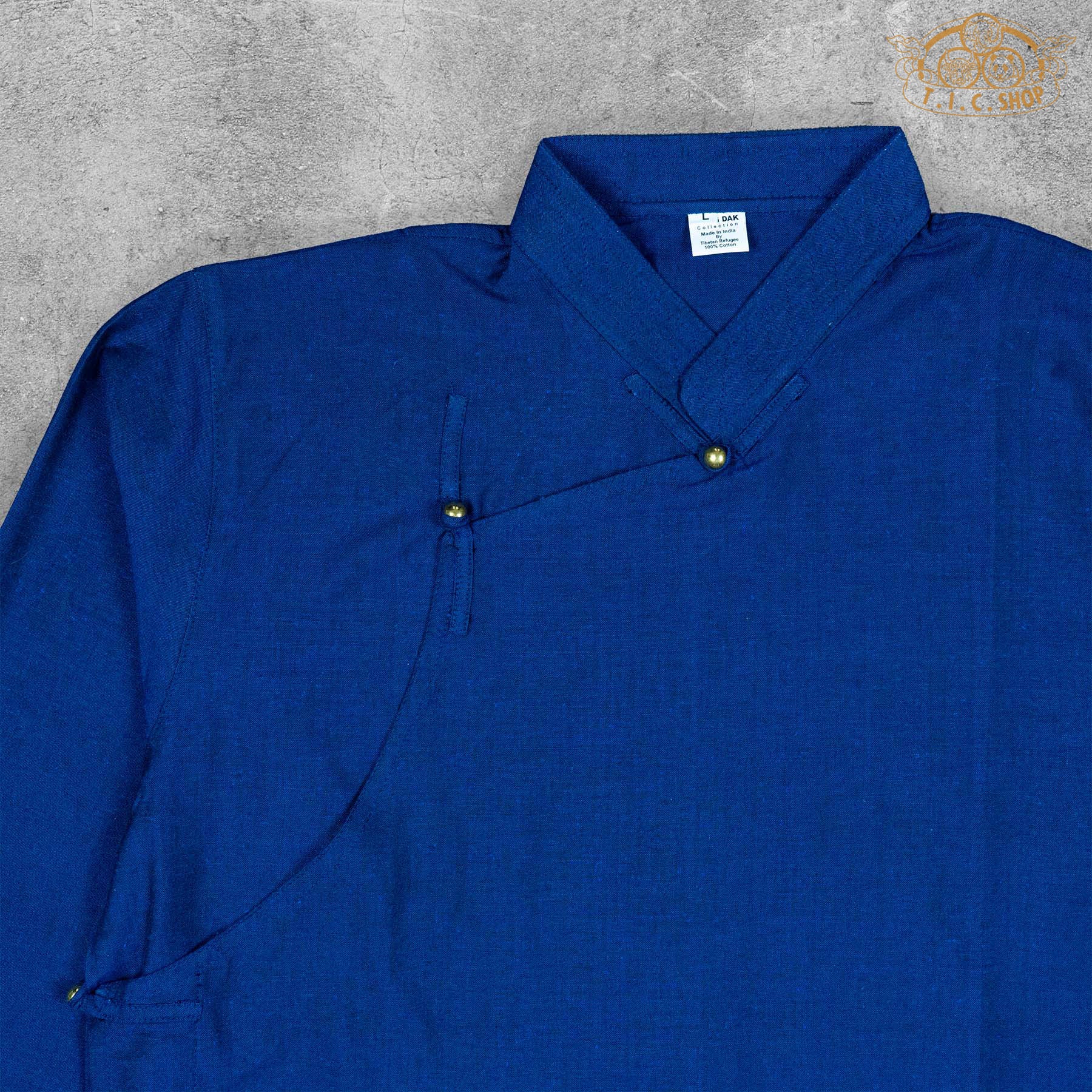 Close-up detail of the cotton fabric texture and stitching of the Tibetan-inspired shirt.