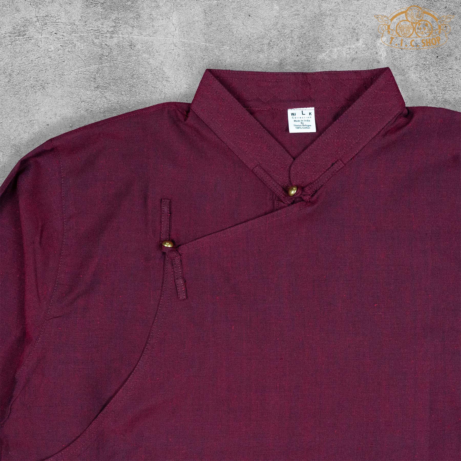 Close-up detail of the cotton fabric texture and stitching of the Tibetan-inspired shirt.