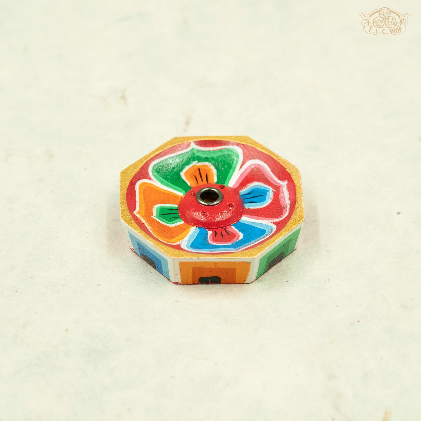 Front view of octagonal Tibetan wooden incense holder with hand-painted lotus flower design.