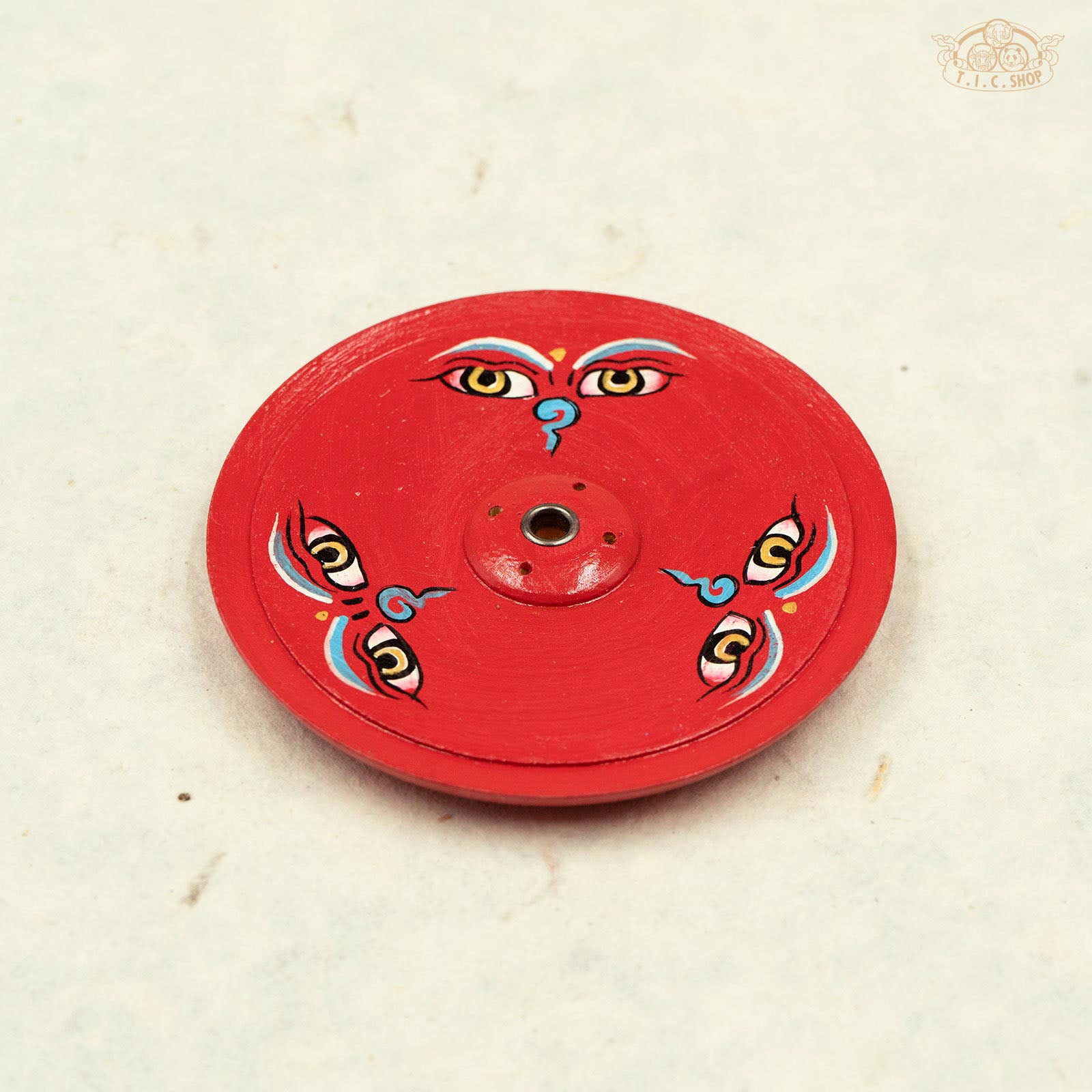 Front view of Tibetan wooden incense holder hand-painted with Buddha eyes symbols.