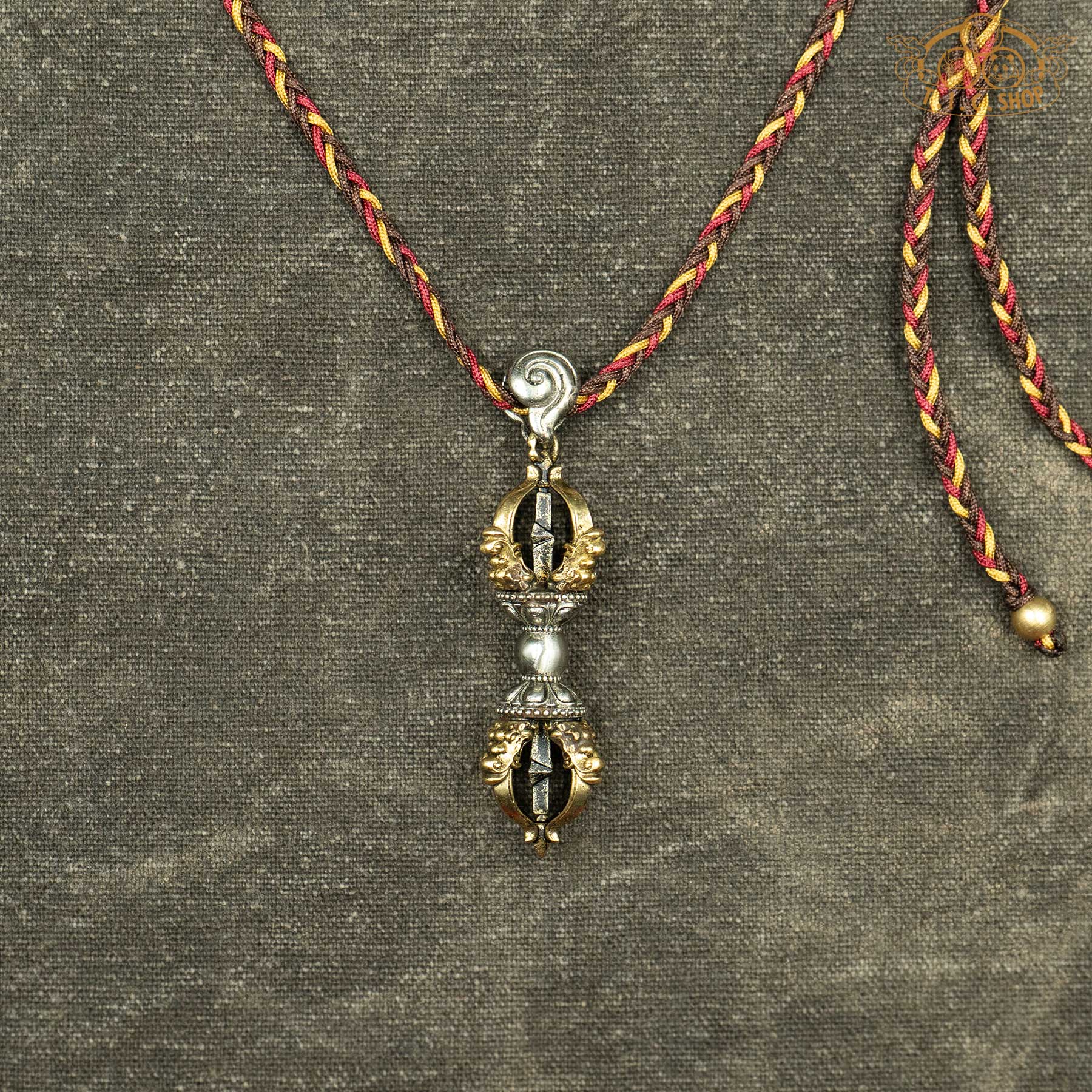 Sculpted brass and cupronickel vajra pendant showing double-ended symmetrical Vajra symbol