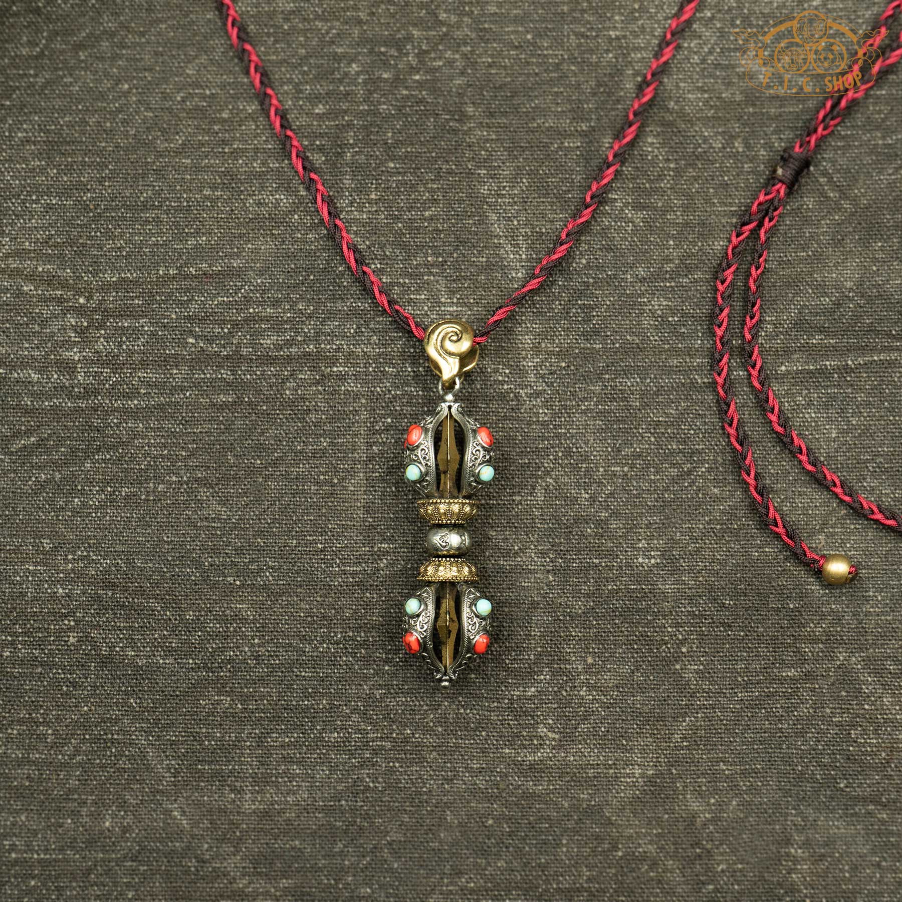 Brass and cupronickel vajra pendant with red and blue beads showing symmetrical Vajra design