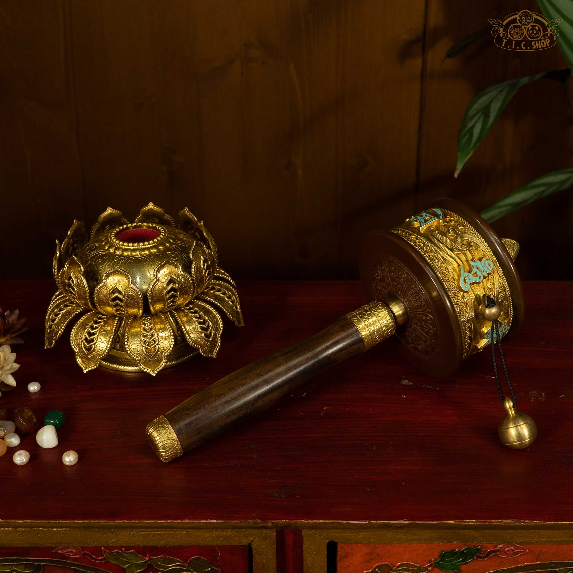 Detailed view of Tibetan prayer wheel with gold filigree and wooden handle