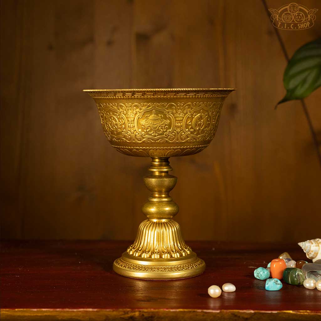 Front view of Tibetan brass butter lamp adorned with Eight Auspicious Symbols and intricate Tibetan patterns.